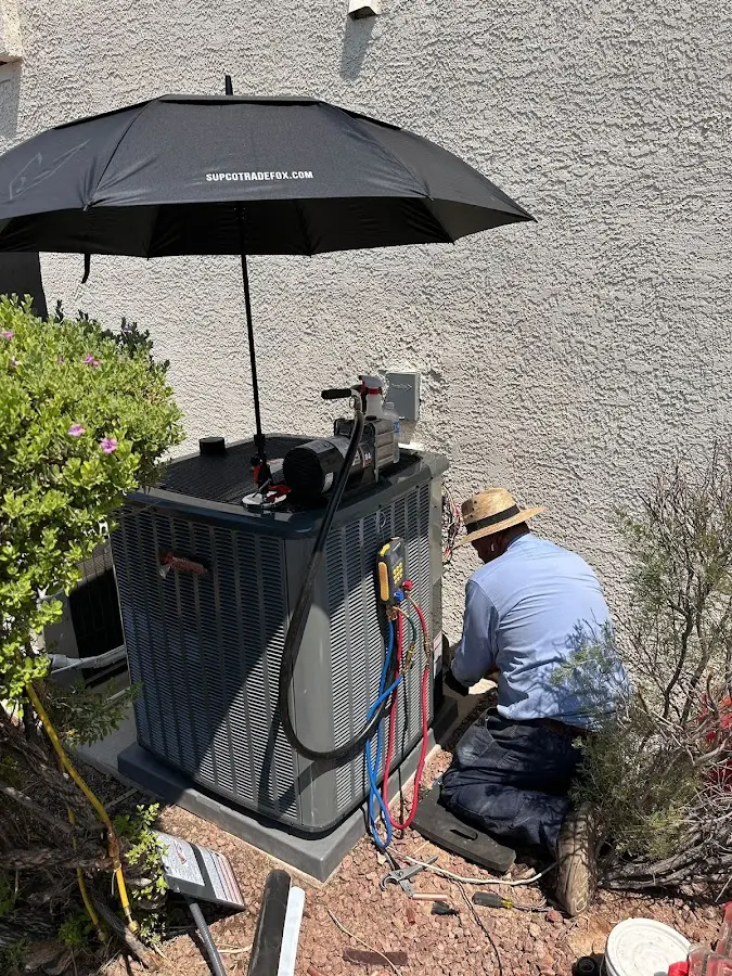 HVAC technician performing outdoor AC maintenance in Franconia