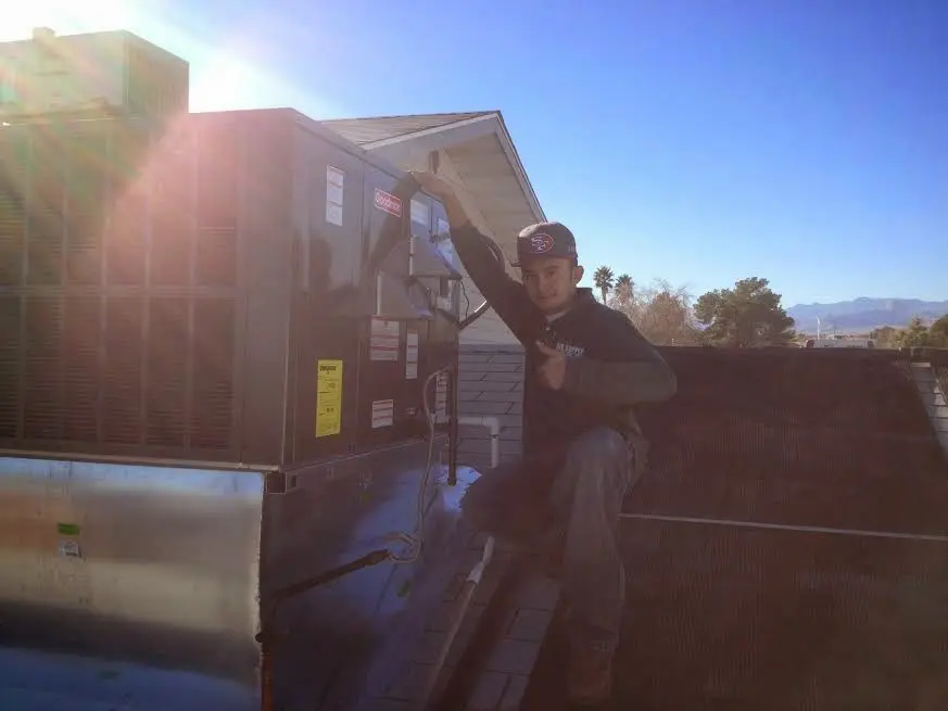 HVAC technician performing AC Tune-Up on a rooftop unit in Franconia